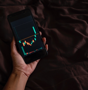 a person holding a cell phone with a chart on the screen