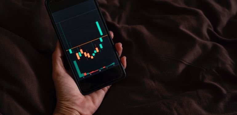 a person holding a cell phone with a chart on the screen