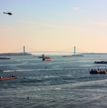 people riding on boat on sea near bridge during daytime