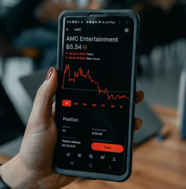 a person holding a cell phone with an amg entertainment app on the screen